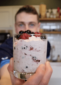 Peter Sawkins holding up a glass filled with Cranachan